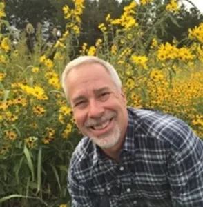 Scott Zerby in a field of yellow flowers